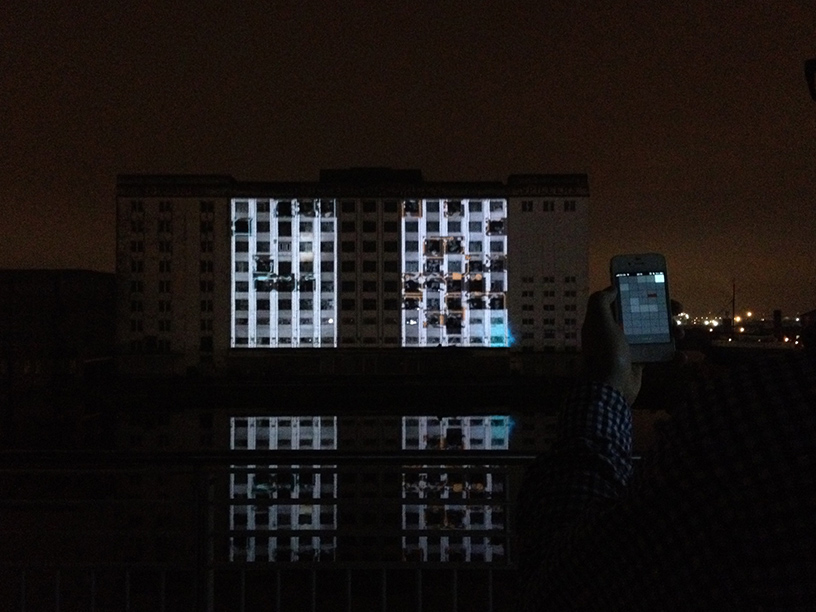 Gameplay footage being projected across the River Thames onto the derelict Millennium Mills